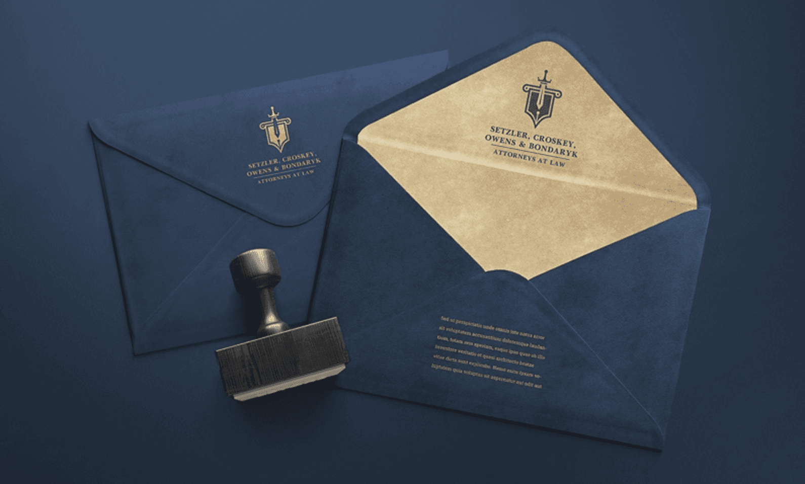 A navy blue envelope with gold logo, paired with a black stamp, featuring a document inside with legal text.